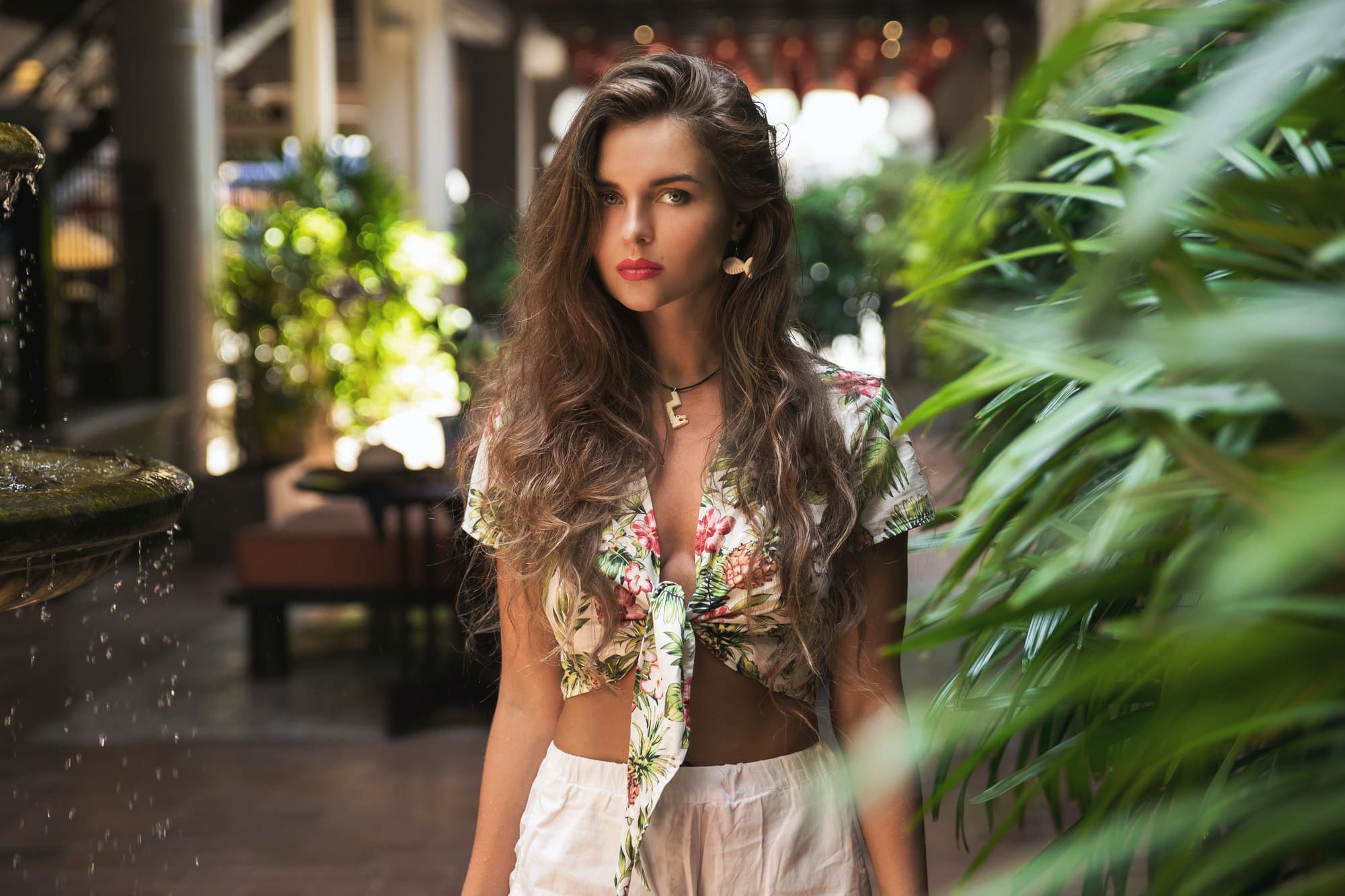 Beautiful woman posing in the yard with the fountain