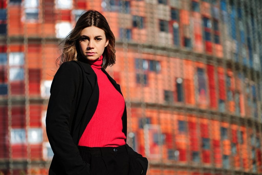 Woman with hands in pockets while posing outdoors.